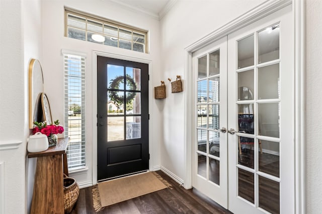 foyer with baseboards, ornamental molding, dark wood finished floors, and french doors