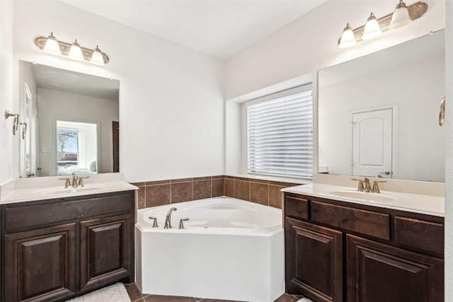 full bathroom with a garden tub, two vanities, and a sink