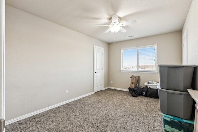 interior space featuring carpet floors, visible vents, baseboards, and a ceiling fan