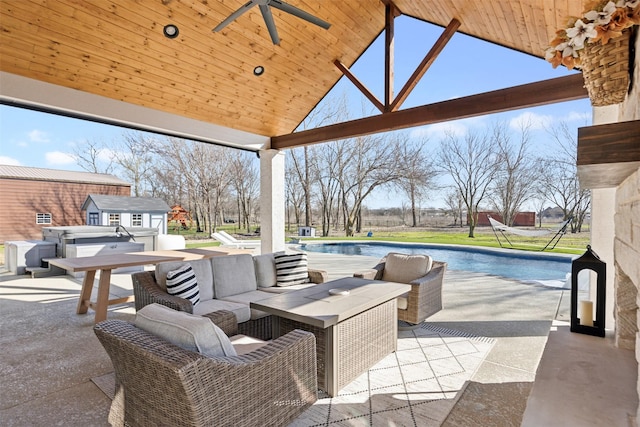 view of patio with an outbuilding, ceiling fan, a jacuzzi, an outdoor pool, and an outdoor living space