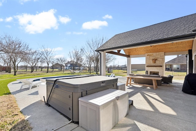 view of patio featuring a gazebo, an outdoor stone fireplace, and a hot tub