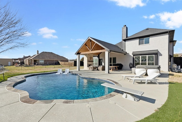 view of swimming pool featuring a patio, fence, a diving board, a yard, and a fenced in pool