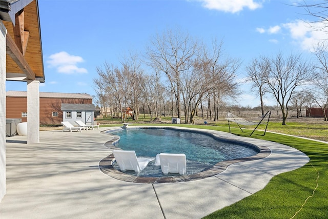 outdoor pool featuring a yard, a storage unit, a patio, and an outdoor structure