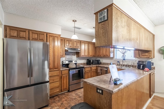 kitchen with under cabinet range hood, a peninsula, visible vents, appliances with stainless steel finishes, and brown cabinets