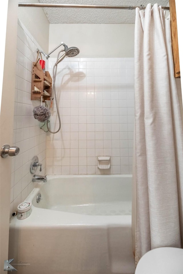 bathroom with a textured ceiling, shower / bath combo, and toilet