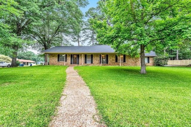 single story home with covered porch, brick siding, fence, and a front lawn