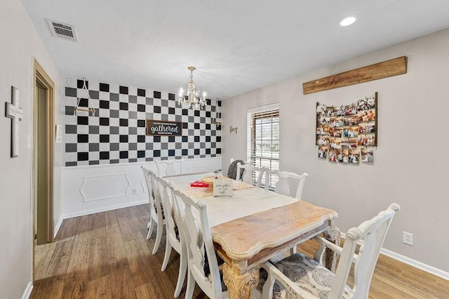 dining space with recessed lighting, a notable chandelier, wood finished floors, visible vents, and baseboards