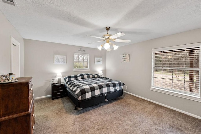 bedroom with baseboards, a textured ceiling, visible vents, and carpet flooring