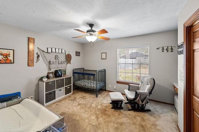 bedroom featuring a ceiling fan, light carpet, a textured ceiling, and baseboards