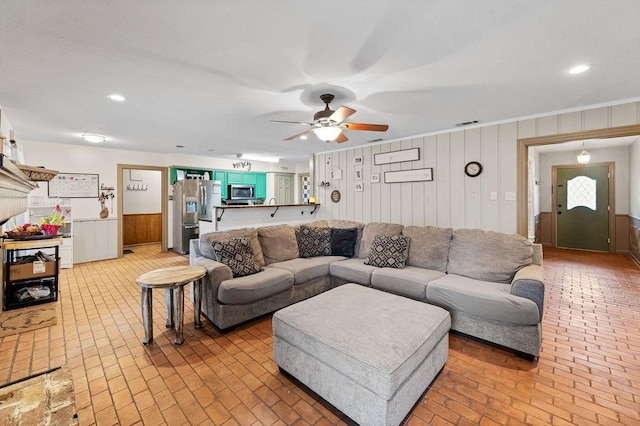 living room with brick floor, visible vents, and recessed lighting