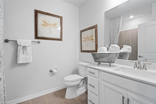 bathroom featuring toilet, tile patterned flooring, baseboards, and vanity