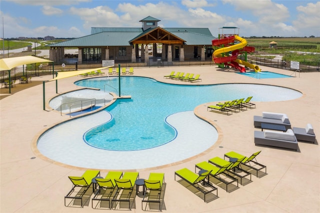 community pool with a water slide, a water play area, and fence