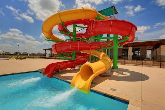 community playground with fence and a water play area