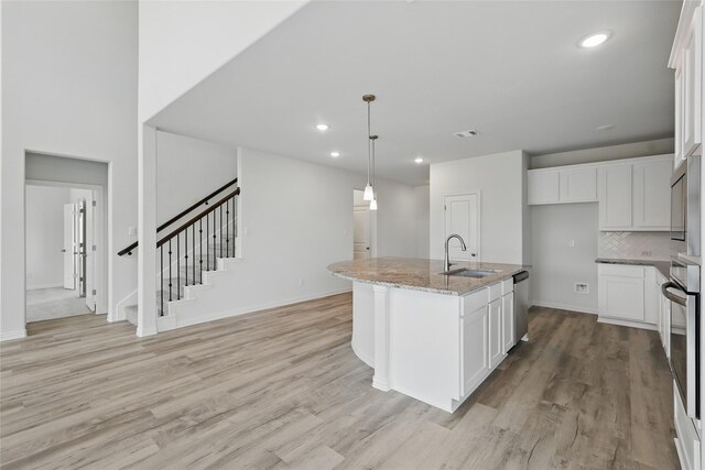 bedroom featuring an accent wall, lofted ceiling, light carpet, and visible vents