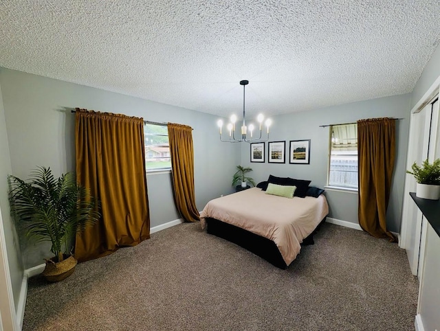 873 Beverly Dr, Terrell, TX 75160 - carpeted bedroom with a chandelier, a textured ceiling, and baseboards