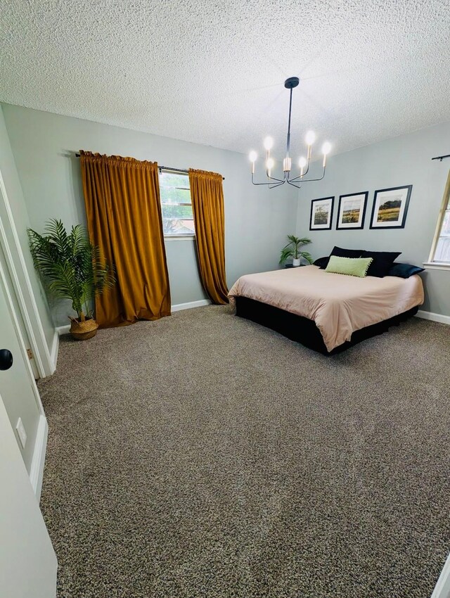 873 Beverly Dr, Terrell, TX 75160 - bedroom featuring a chandelier, carpet floors, multiple windows, and a textured ceiling