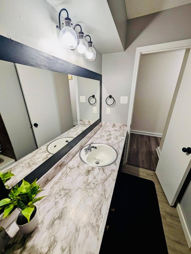 873 Beverly Dr, Terrell, TX 75160 - bathroom with wood finished floors, vanity, and baseboards