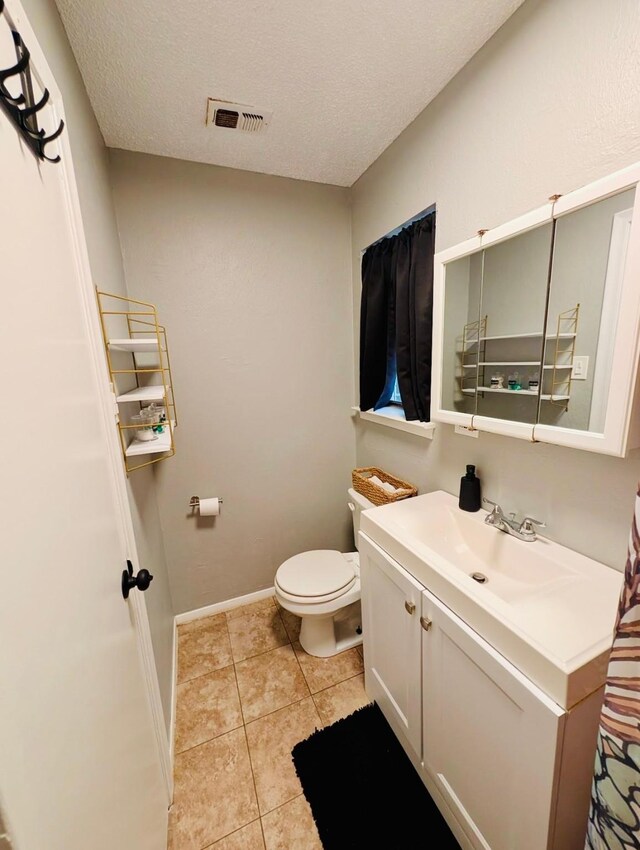 873 Beverly Dr, Terrell, TX 75160 - bathroom featuring toilet, tile patterned floors, vanity, baseboards, and a textured ceiling