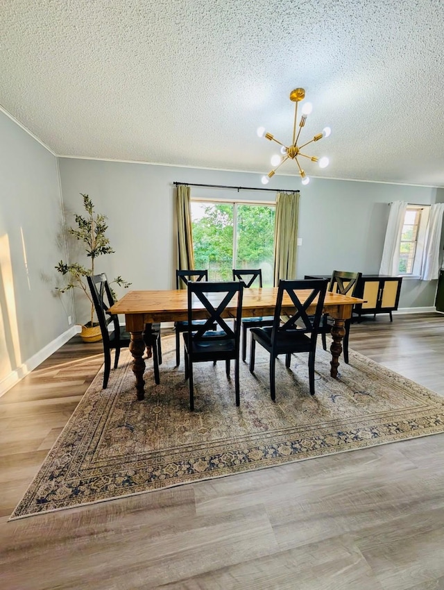 873 Beverly Dr, Terrell, TX 75160 - dining room featuring a chandelier, healthy amount of natural light, a textured ceiling, and wood finished floors