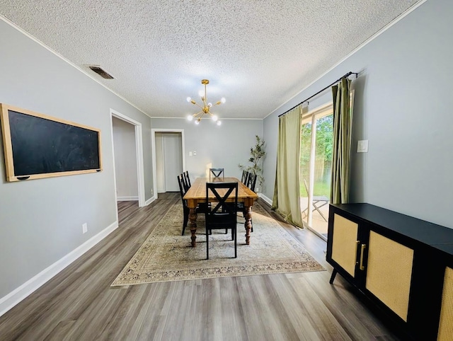 873 Beverly Dr, Terrell, TX 75160 - dining space featuring a chandelier, wood finished floors, ornamental molding, a textured ceiling, and baseboards
