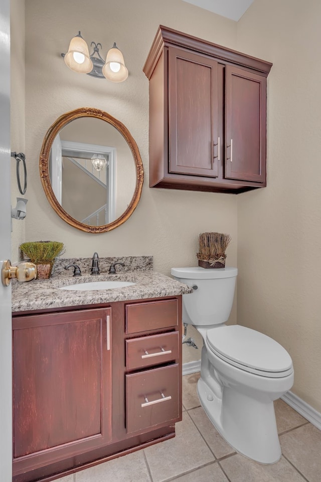 bathroom with toilet, tile patterned flooring, baseboards, and vanity