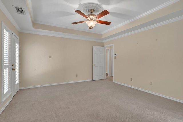 spare room featuring light carpet, baseboards, visible vents, a tray ceiling, and crown molding