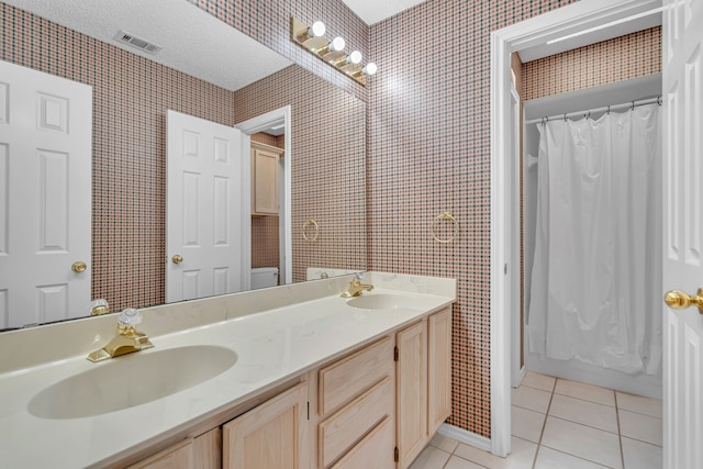 full bath featuring tile patterned floors, a sink, visible vents, and wallpapered walls