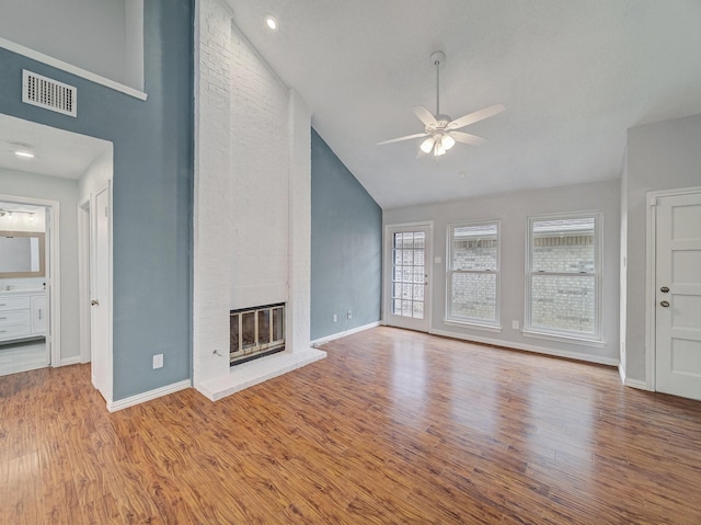 unfurnished living room featuring visible vents, a fireplace, ceiling fan, and wood finished floors