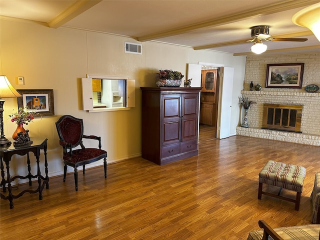 sitting room featuring visible vents, beamed ceiling, and wood finished floors