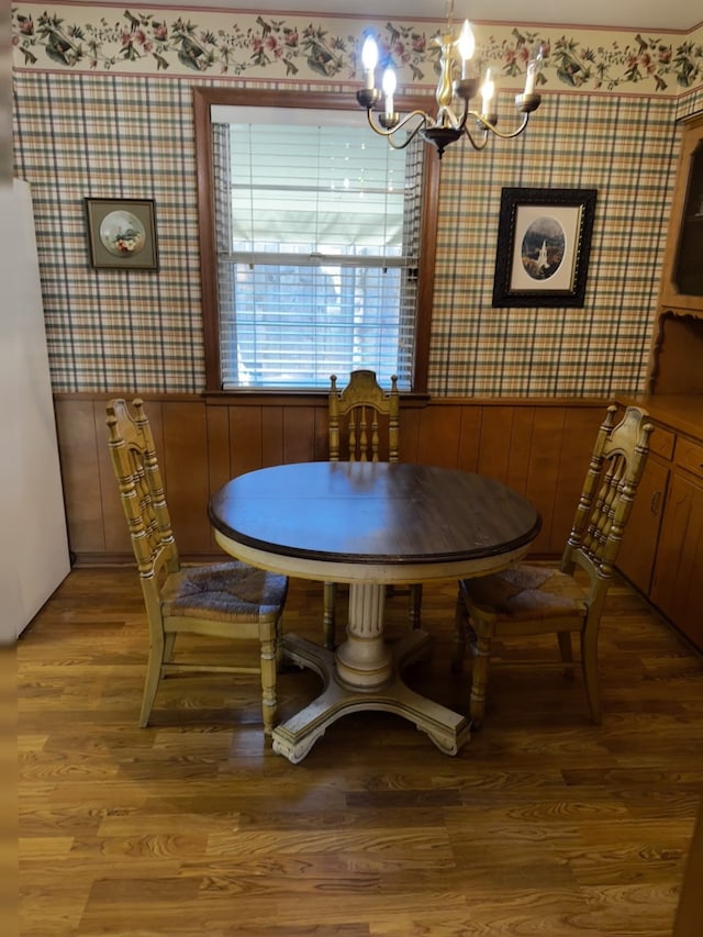 dining area featuring wallpapered walls, light wood-style flooring, and an inviting chandelier