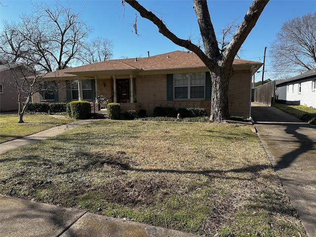 single story home featuring a front yard and brick siding