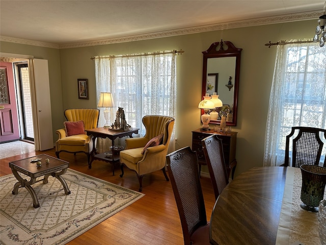 living area featuring ornamental molding and wood finished floors