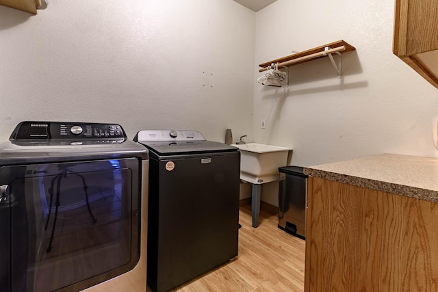 washroom with laundry area, light wood-type flooring, and independent washer and dryer