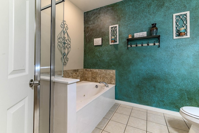 bathroom with baseboards, a tub with jets, toilet, and tile patterned floors