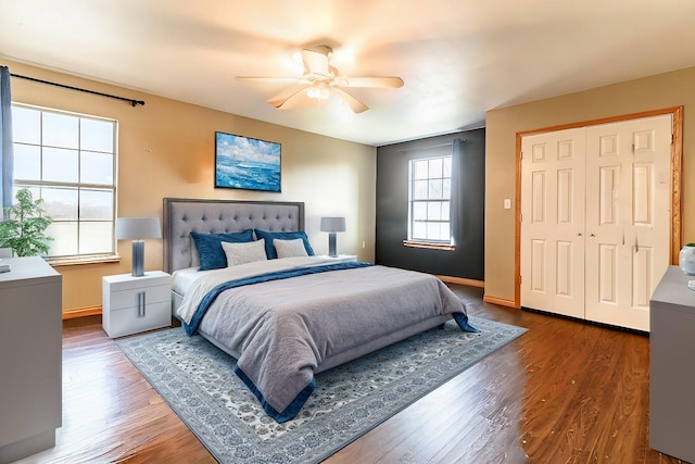 bedroom with dark wood-style floors, ceiling fan, and baseboards