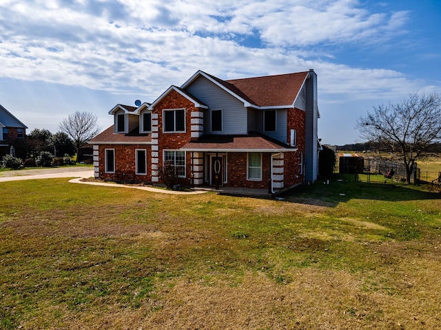 view of front facade with fence, a front lawn, and brick siding