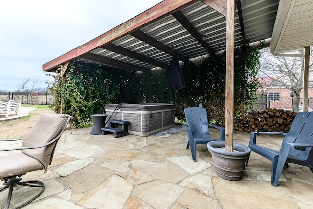 view of patio featuring a hot tub, fence, and a pergola