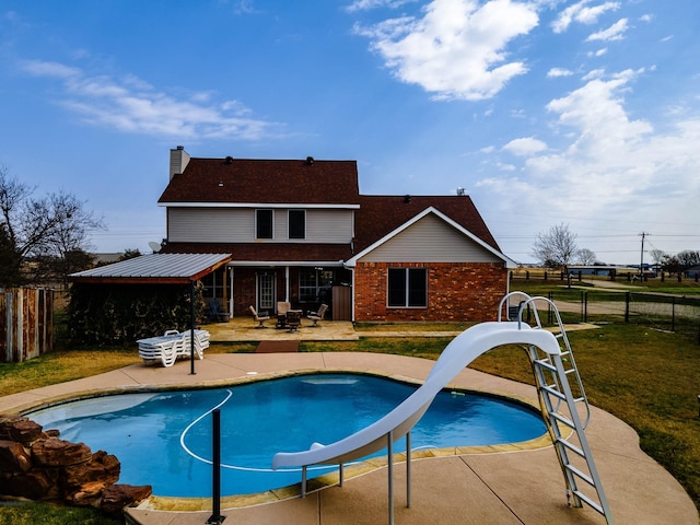 view of pool with a fenced backyard, a water slide, and a patio