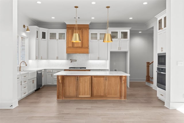 kitchen featuring a kitchen island, glass insert cabinets, appliances with stainless steel finishes, light countertops, and white cabinetry