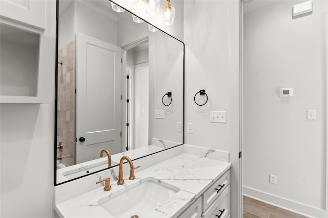 bathroom with vanity, baseboards, and wood finished floors