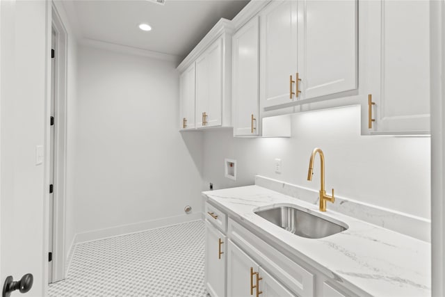 laundry area with cabinet space, baseboards, washer hookup, a sink, and recessed lighting