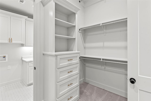 spacious closet featuring visible vents and light carpet