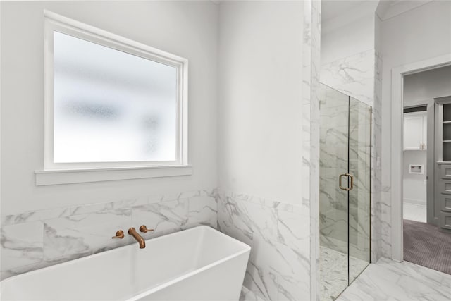 bathroom featuring a marble finish shower, a wainscoted wall, marble finish floor, a freestanding tub, and tile walls