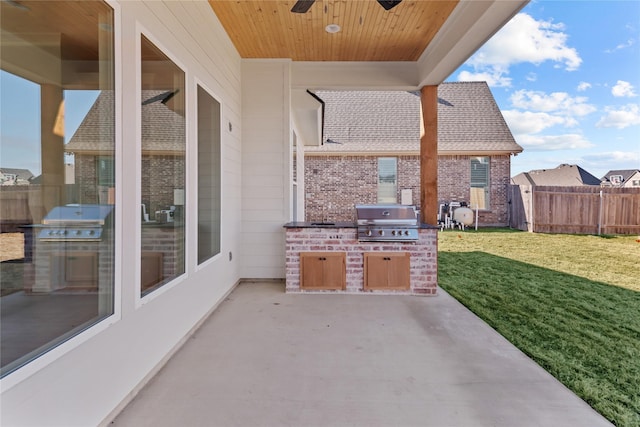 view of patio with ceiling fan, grilling area, fence, and an outdoor kitchen