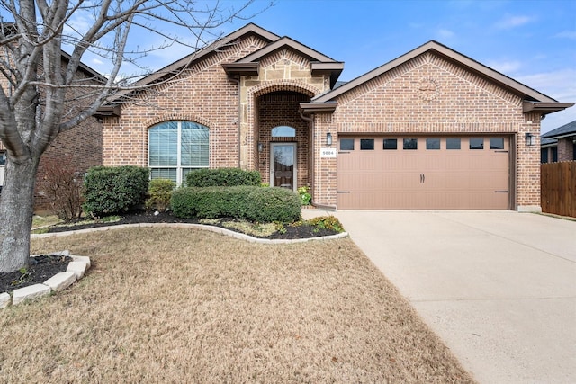 single story home with a garage, driveway, a front yard, and brick siding