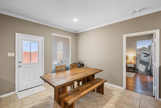 dining area featuring light tile patterned floors, ornamental molding, and baseboards