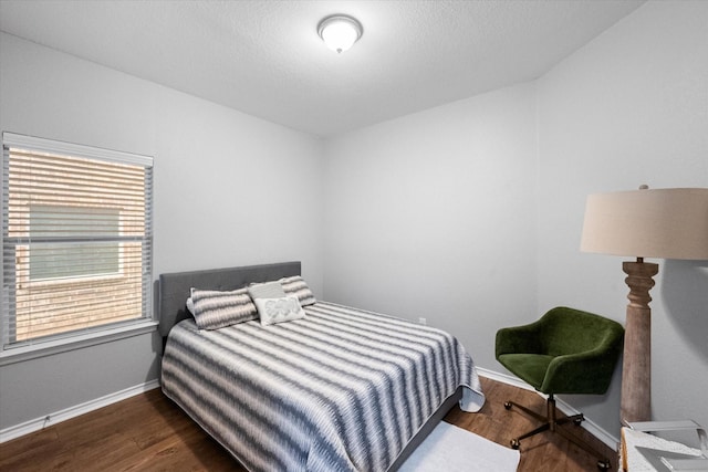 bedroom with baseboards and dark wood finished floors