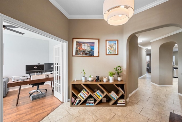 interior space featuring baseboards, arched walkways, and crown molding