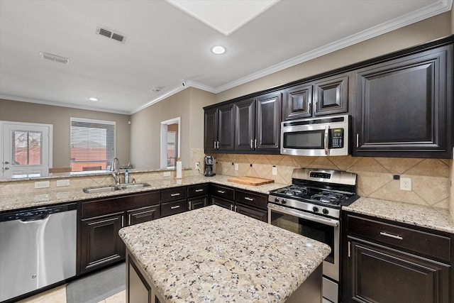 kitchen featuring tasteful backsplash, visible vents, appliances with stainless steel finishes, a sink, and light stone countertops