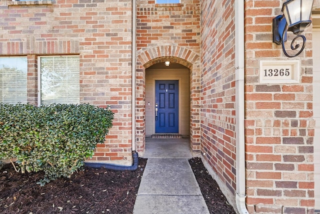 view of exterior entry featuring brick siding